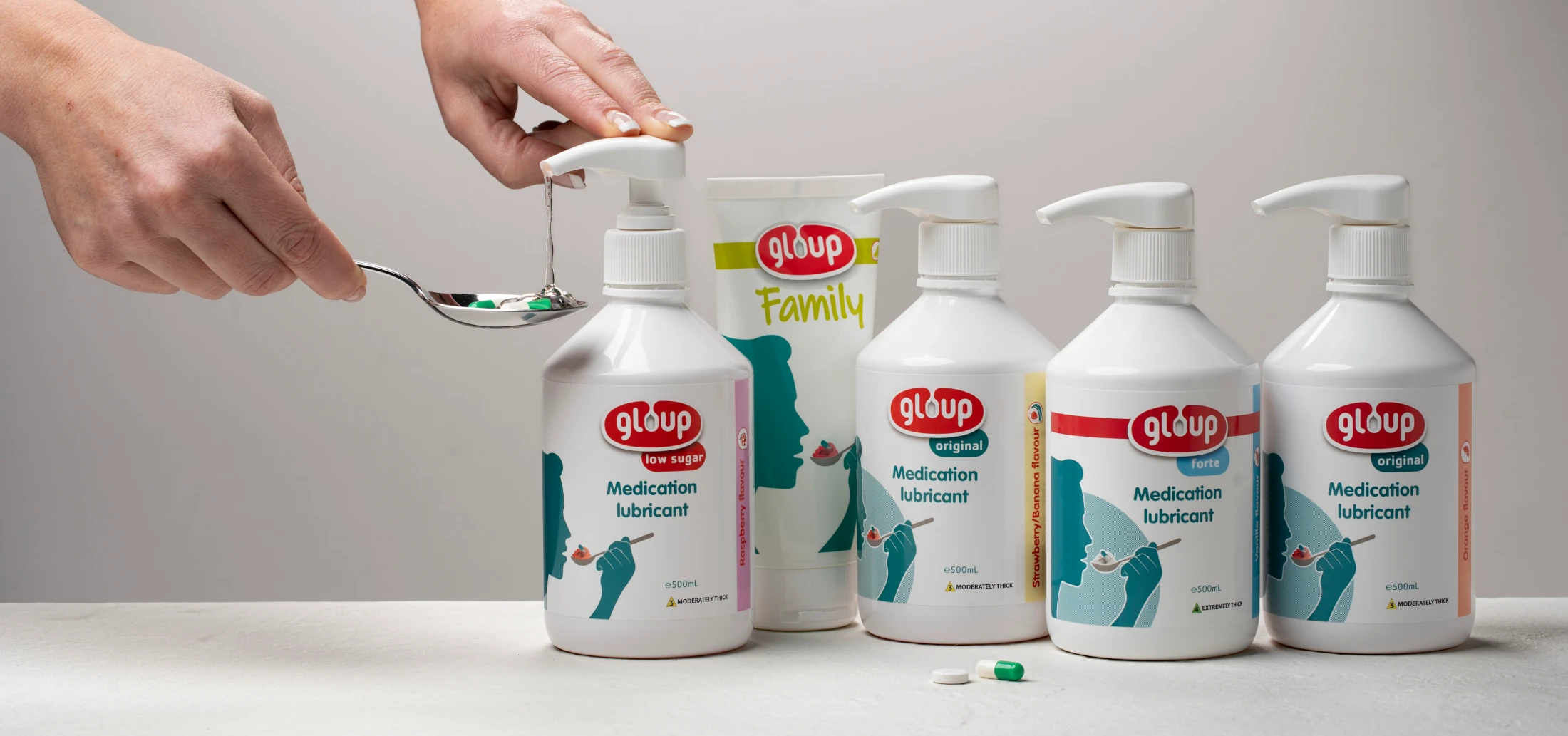 Gloup medication lubricant product family — hand, spoon and product bottles